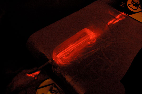 A laser is pointed into the gel, lighting it up.