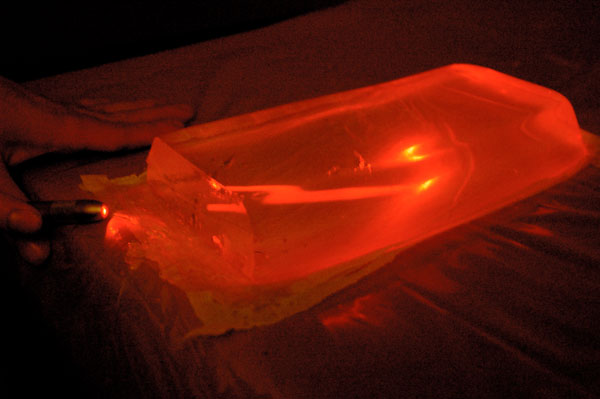 The laser is pointed into the gel from an angle, making it bounce off the side and back into the gel.